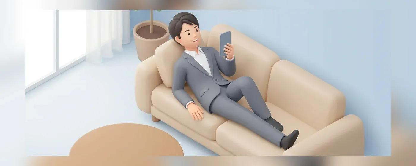 ソファに座りスマートフォンを手にして安心した表情を浮かべる若手社員