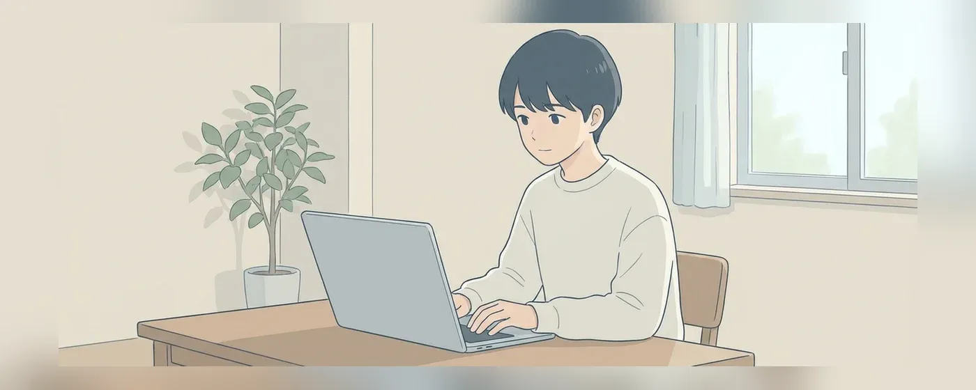 机に向かってノートPCで真剣に作業する若者